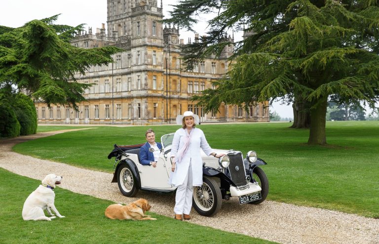 Earl and Countess Carnarvon in front of Highclere Castle with their dogs. Imagery courtesy of Highclere Castle Gin.