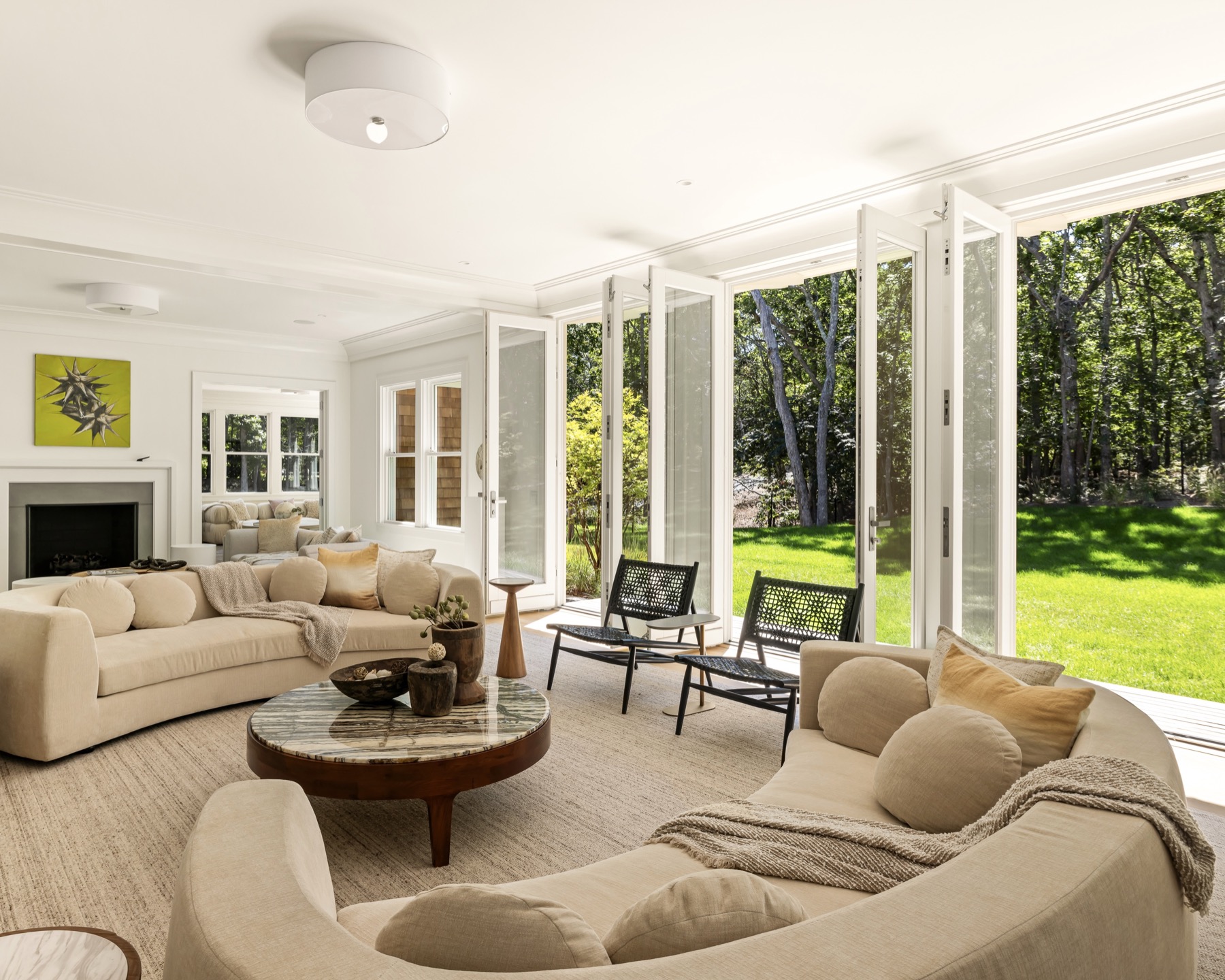 Living room with a fireplace and folding doors opening to the garden at 62 Canvasback Lane