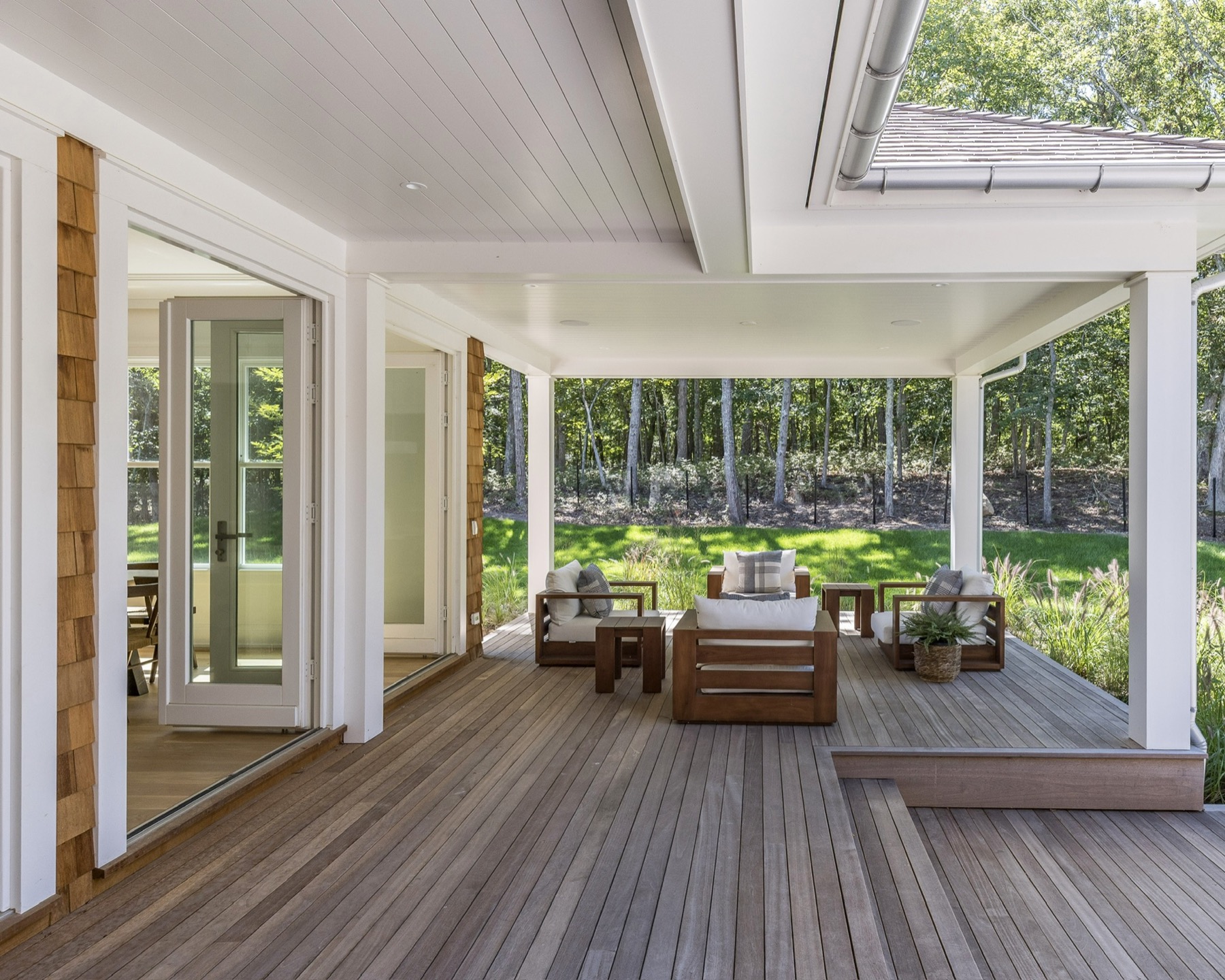Covered terrace and outdoor seating overlooking the wooded garden